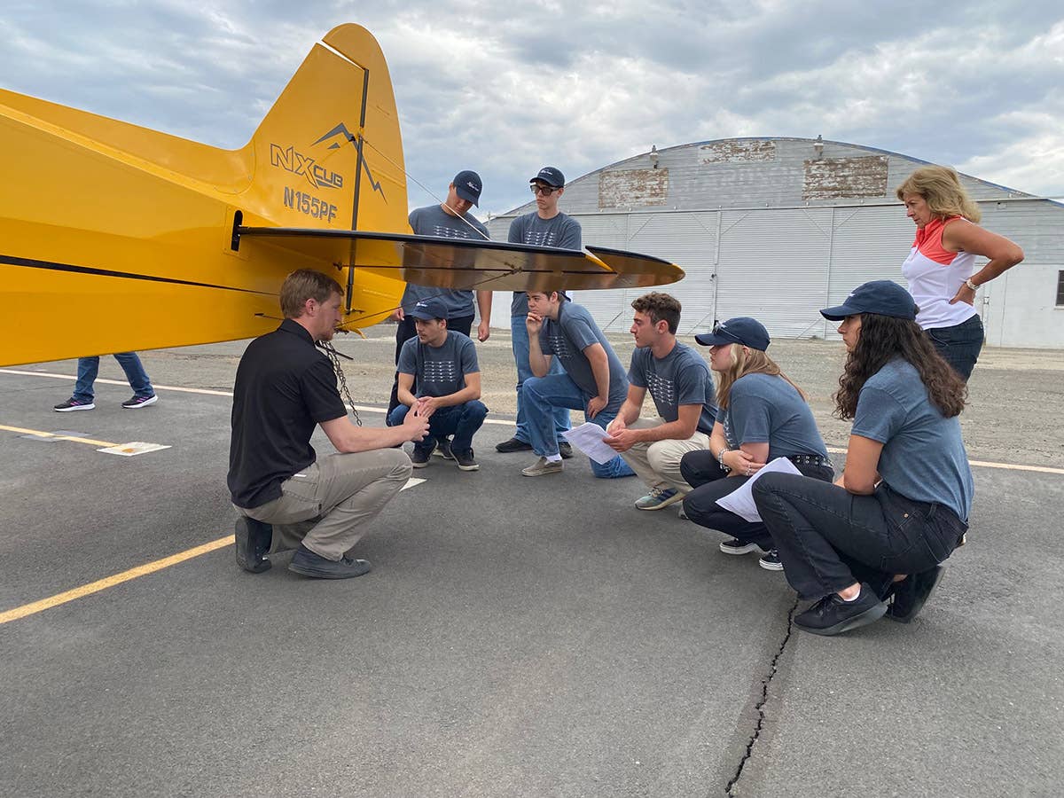 High school students looking at a CubCrafters NX aircraft