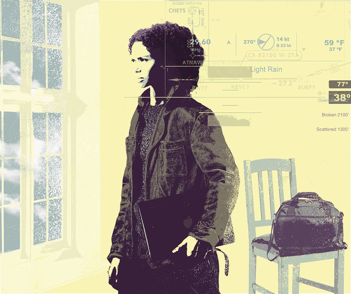 A young woman looks with concern out of a window. A flight bag sits on a nearby chair.